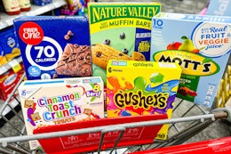 fiber one bars, nature valley bars, motts fruit snacks, gushers, and cinnamon toast crunch bars in a cart
