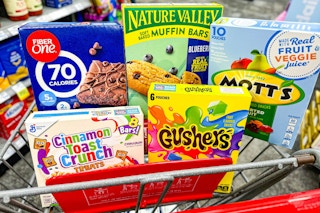 fiber one bars, nature valley bars, motts fruit snacks, gushers, and cinnamon toast crunch bars in a cart