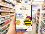 hand holding zarbees sleep tablets in walmart aisle