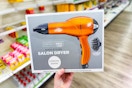 person holding a hair dryer box in an aisle