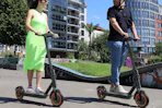a woman and man riding e-scooters