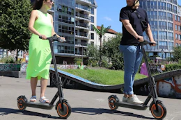 a woman and man riding e-scooters