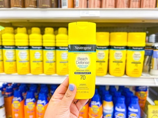 hand holding neutrogena beach defense sunscreen lotion in front of target shelf
