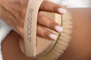 a woman using a dry body brush