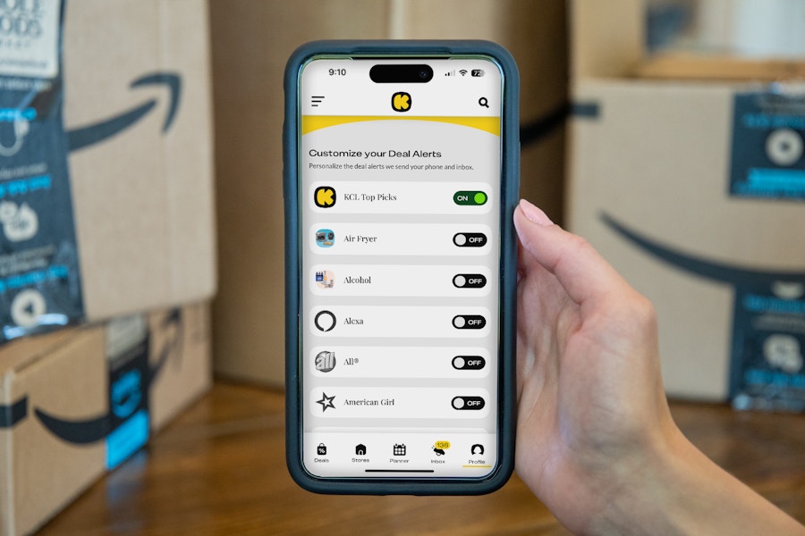 a person's hand holding up a phone showing how to set up amazon deal alerts with the krazy coupon lady app