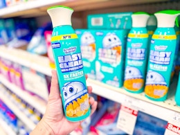 hand holding a scrubbing bubbles cleaner in front of target shelves