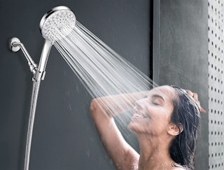 A woman showering underneath a showerhead.