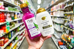 hand holding maui moisture and ogx hair care at dollar general
