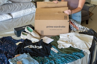 A woman unpacking an amazon prime wardrobe order from a box.