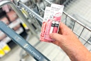 person holding 2 covergirl lip colors over a walgreens cart