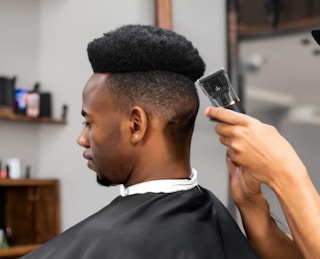 a barber using hair clippers