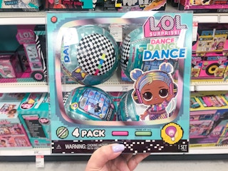 hand holding a 4-pack of lol surprise dance dance dance dolls at target
