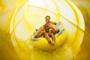 A family playing and swimming in the water in the pool area at an indoor Great Wolf Lodge