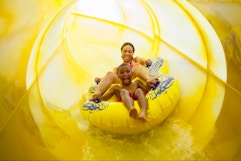 A family playing and swimming in the water in the pool area at an indoor Great Wolf Lodge