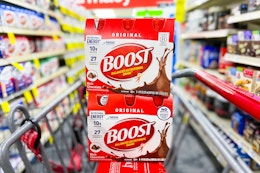 two boost drink packs in a cvs shopping cart in a store aisle