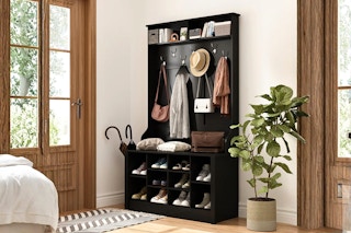 Lifestyle image of a black entryway bench with coat rack from Lowe's (in home setting)