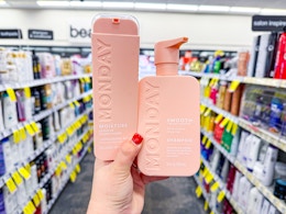 hand holding two monday haircare products