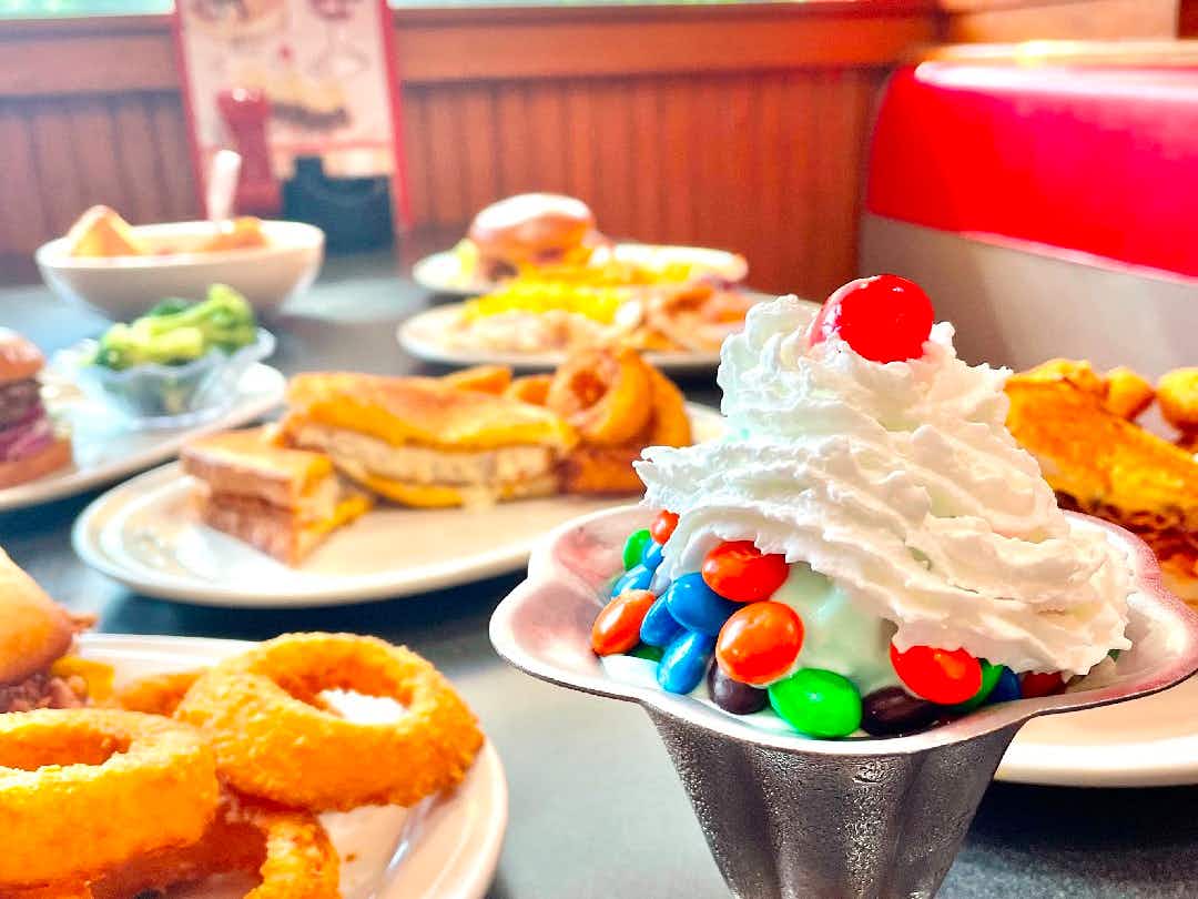 Plates of onion rings sandwiches and a bowl of ice cream at Friendly's