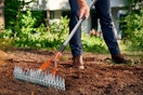 man using rake in yard