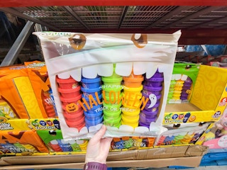 hand holding a 50-pack of crayola silly scents dough in a halloween trick or treating pack