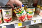 hand grabbing a can of rotel tomatoes