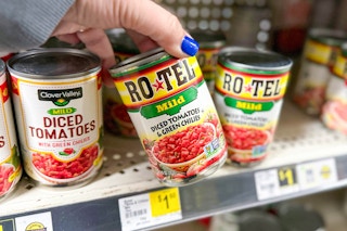 hand grabbing a can of rotel tomatoes
