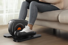 a woman using an under desk elliptical