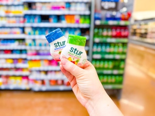 hand holding two stur water enhancers in walmart drink aisle
