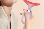 a woman holding a face massager