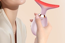 a woman holding a face massager