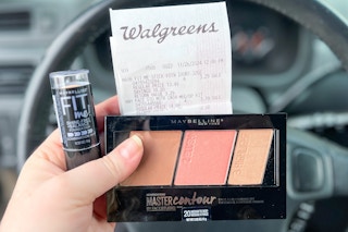 hand holding maybelline foundation and contour kit with a walgreens receipt