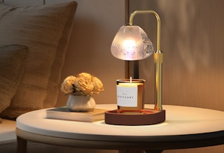 a candle warmer with a candle on a small table 