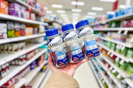hand holding up a pack of ensure nutrition shakes