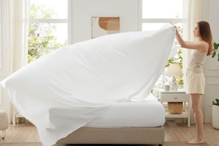 woman putting Bedsure queen sheet set on bed