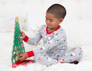 a kid playing with a Christmas tree advent calendar