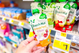 hand holding beech-nut baby food next to store shelf