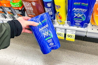 person holding a 2-pack of arrid deodorant by a 90% off clearance sign