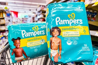 two packs of pampers swaddlers diapers balancing on shopping cart at walgreens