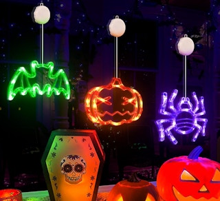 bat, pumpkin, and spider neon lights hanging on a window