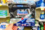 hand holding a pack of finish quantum dishwasher detergent