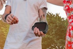 man holding portable speaker outside