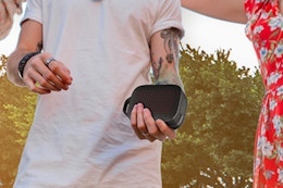 man holding portable speaker outside