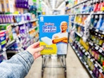 hand holding a pack of mr clean magic erasers in walmart aisle
