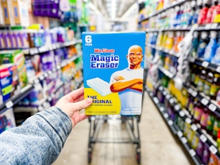 hand holding a pack of mr clean magic erasers in walmart aisle