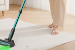 a woman using a cordless vacuum