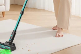 a woman using a cordless vacuum
