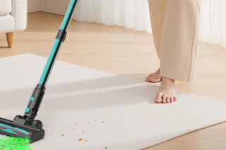 a woman using a cordless vacuum