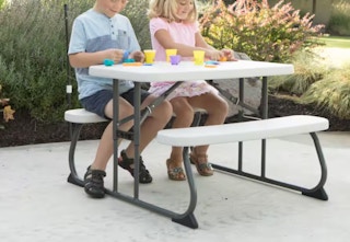 kids playing with toys on a white folding picnic table
