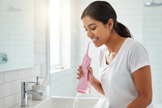 a woman using a water flosser