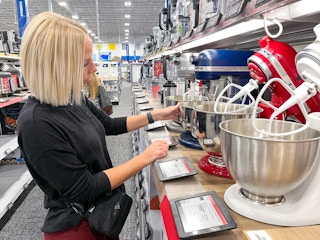 A woman looking at KitchenAid mixers at Best Buy